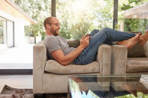 Man relaxing on sofa using tablet PC